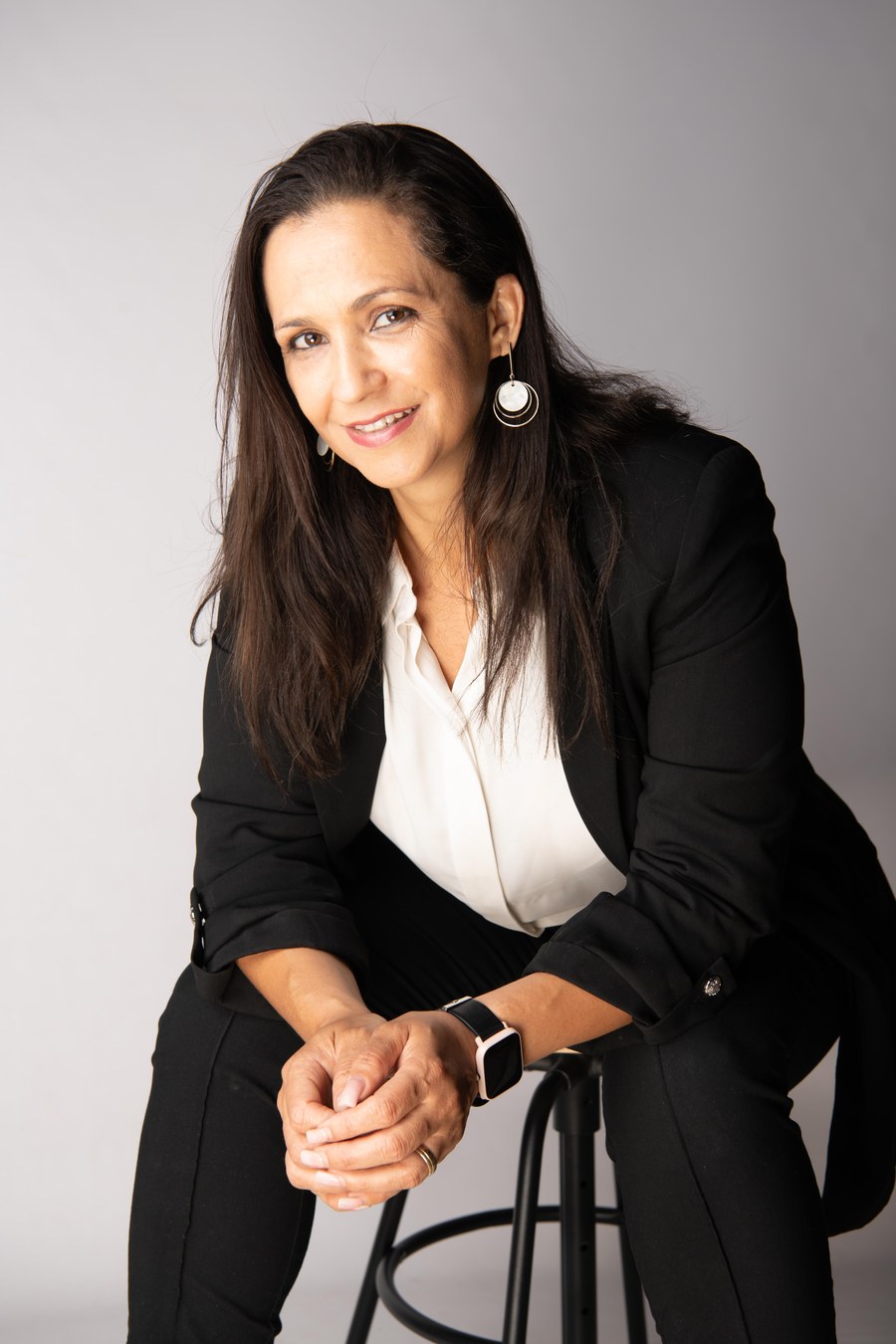 Daisy Satel, neuropsicanalista, sentada segurando um livro de neurociência, retrato editorial
